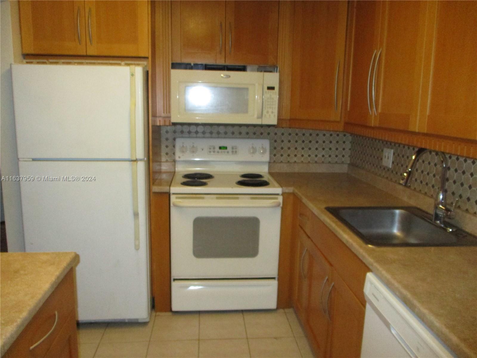 a kitchen with a stove sink and cabinets