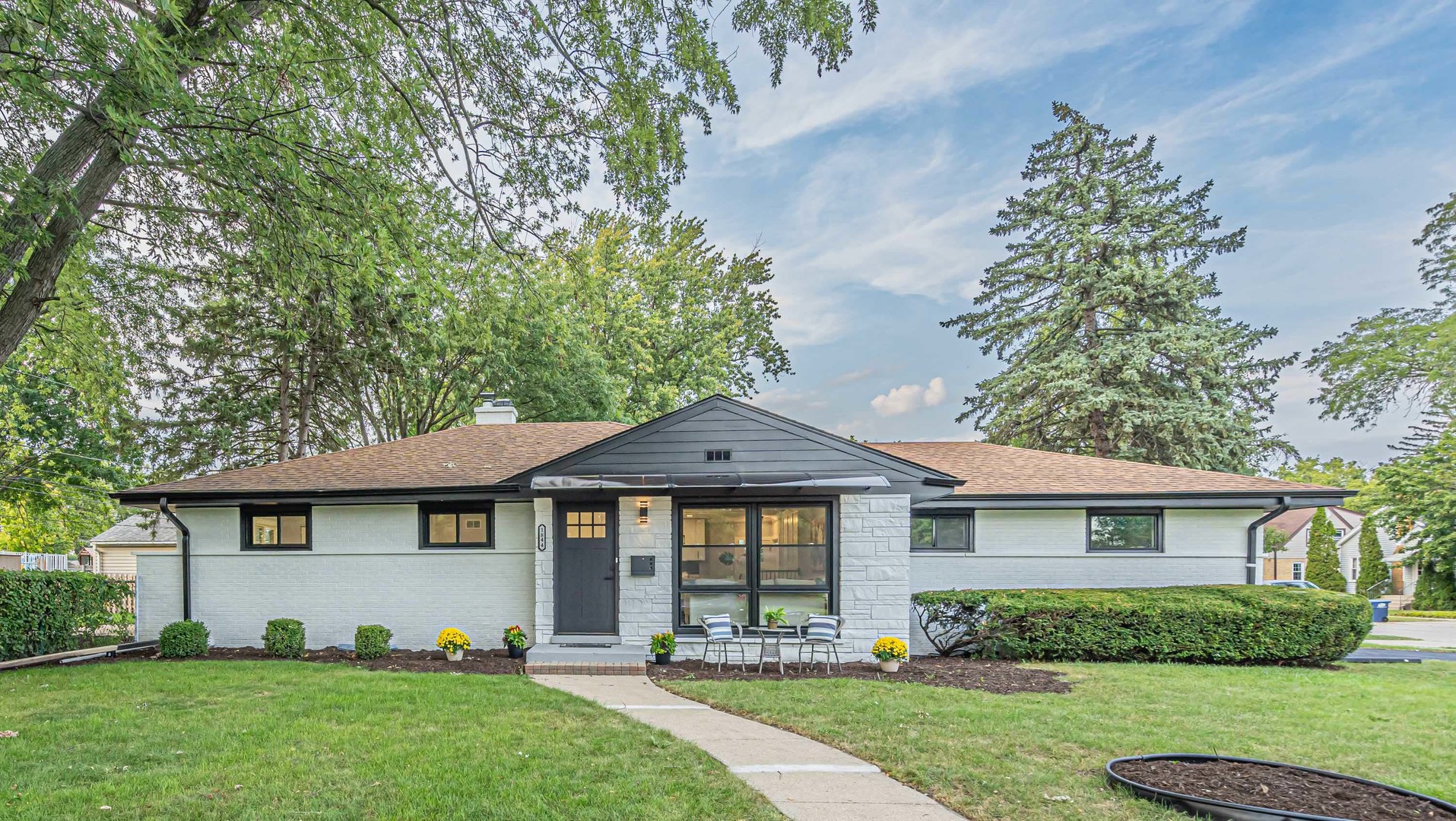 a front view of a house with a yard and potted plants