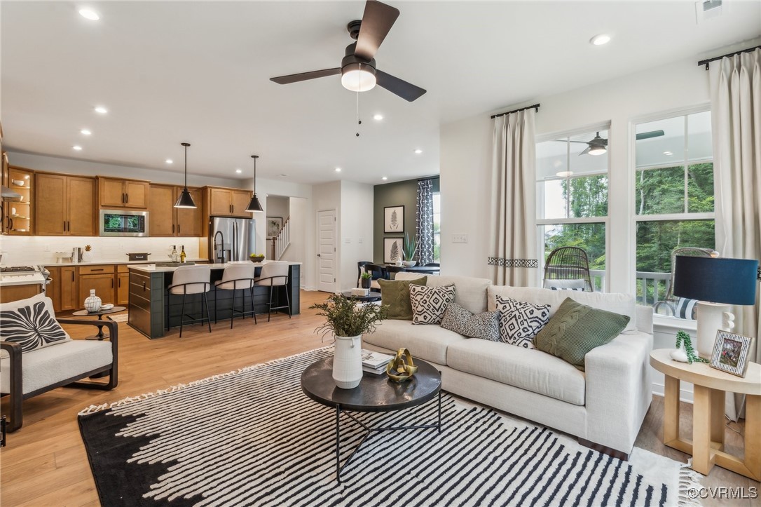 a living room with furniture kitchen view and a large window