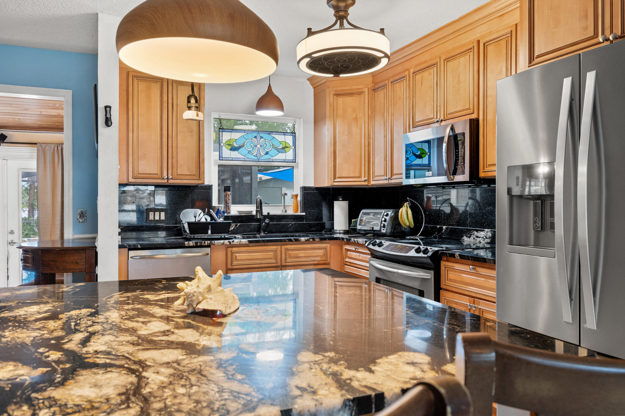 a kitchen with stainless steel appliances granite countertop a stove refrigerator and cabinets