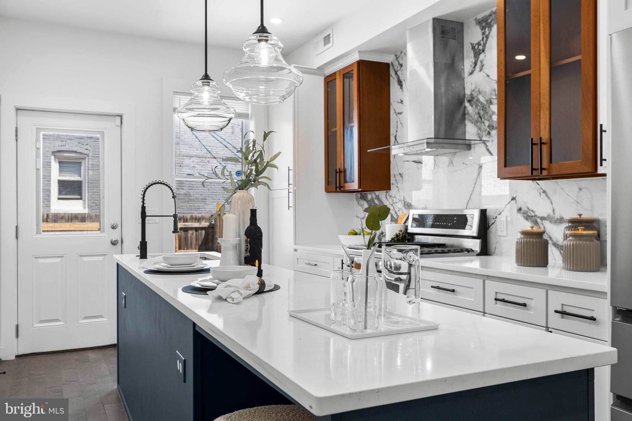 a kitchen with kitchen island granite countertop a sink a stove and cabinets