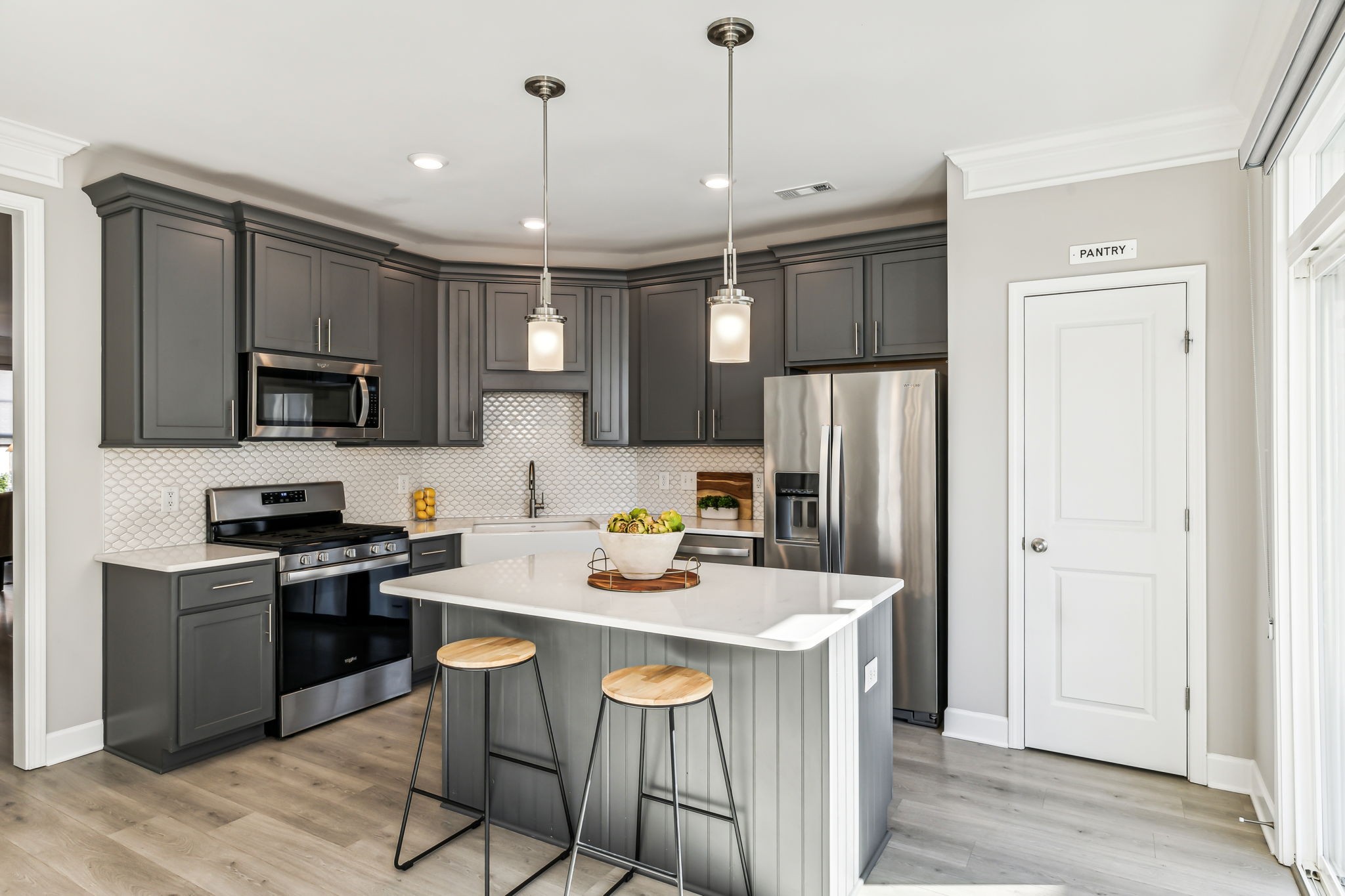 a kitchen with a sink a kitchen island stainless steel appliances cabinets and a center island