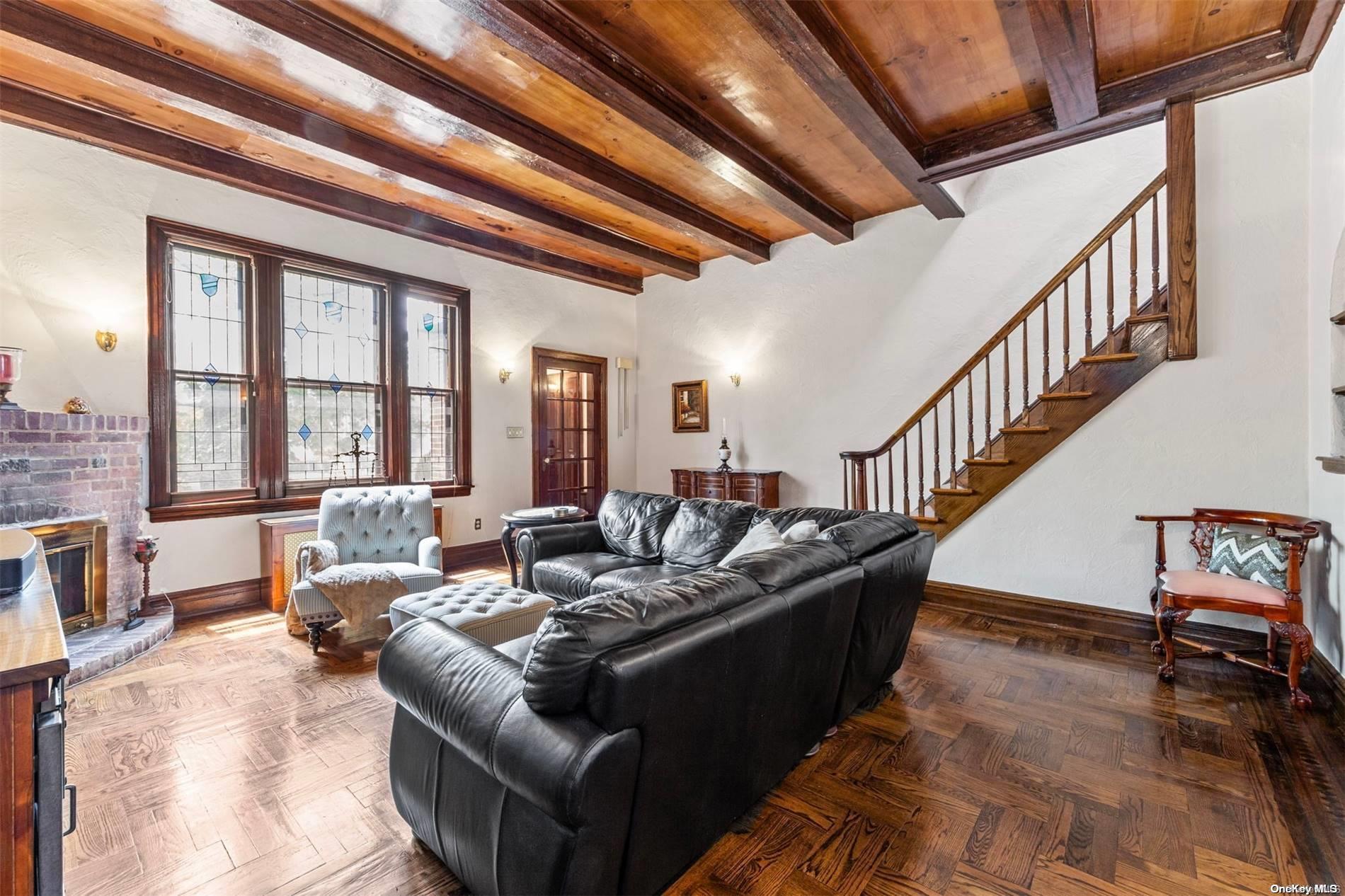 a living room with furniture stairs and a large window