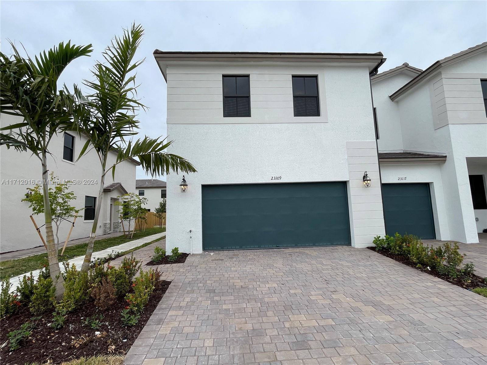 a front view of a house with a yard and garage