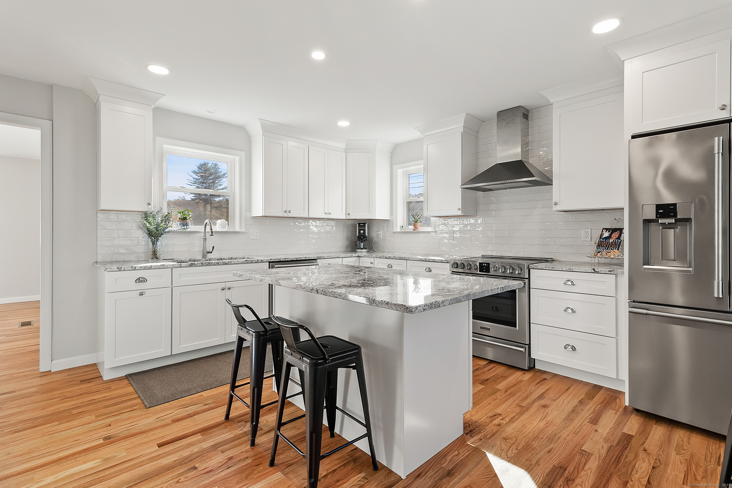 a kitchen with a refrigerator a sink and wooden floors