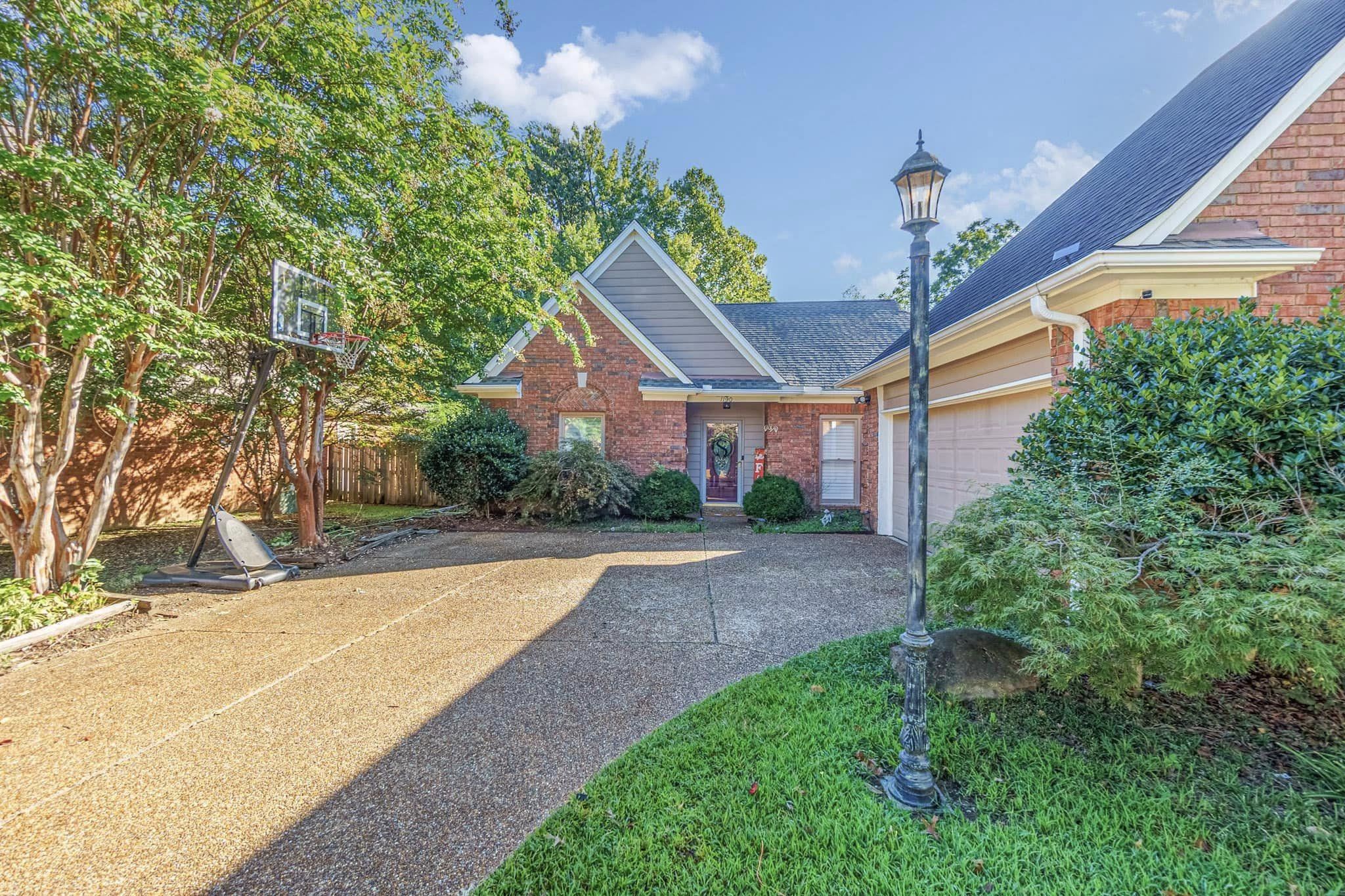 a view of a house with a yard and potted plants