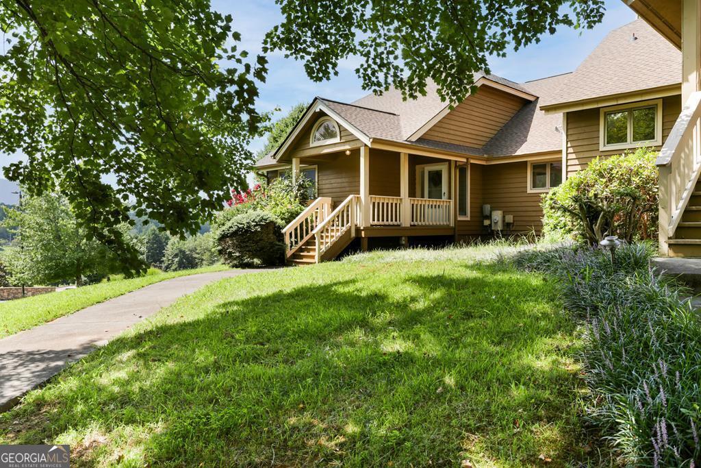 a front view of a house with a yard and trees