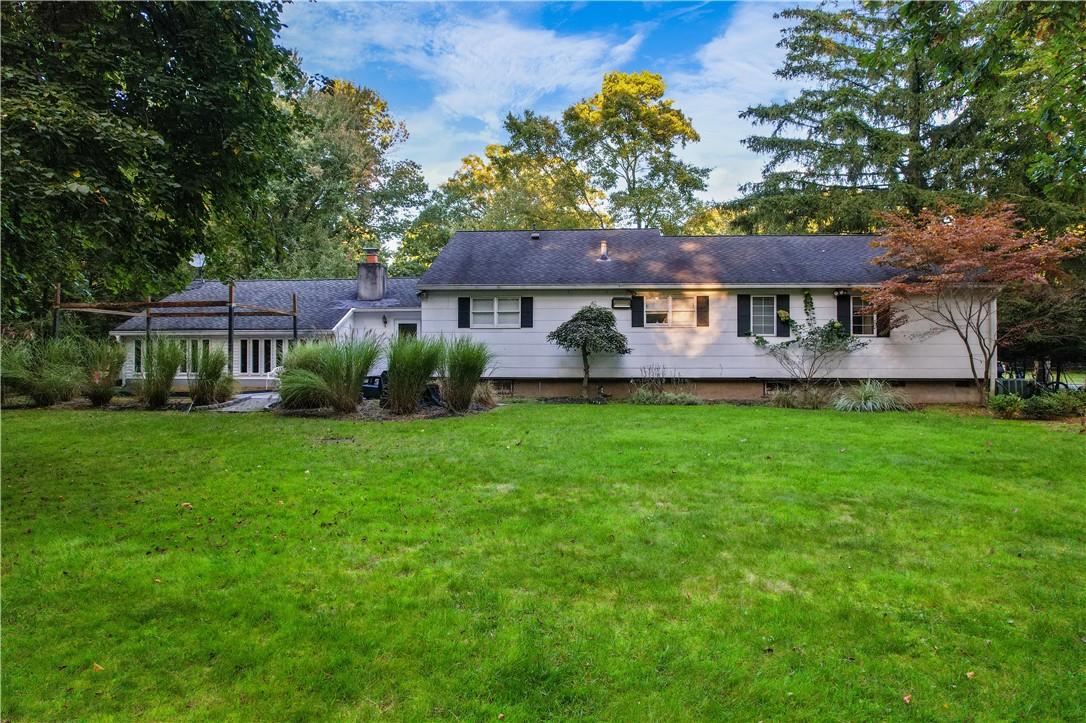 a front view of a house with a garden and trees