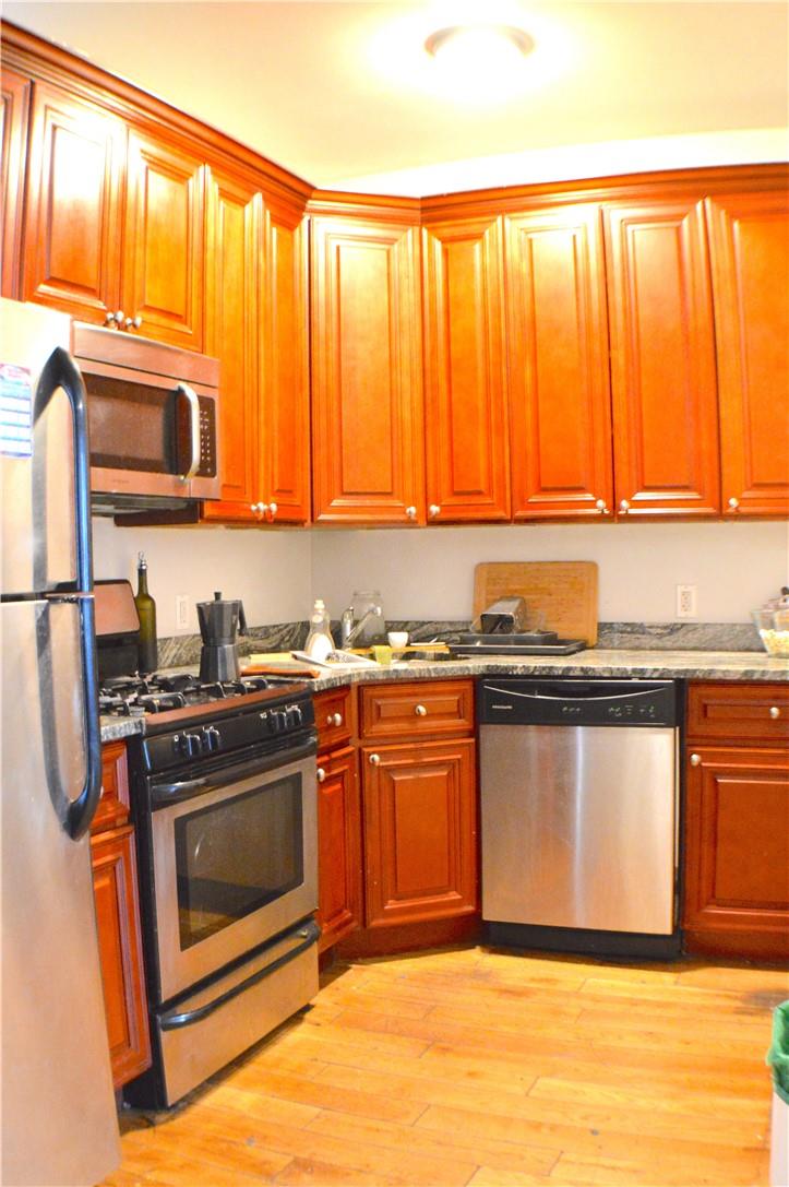 a kitchen with stainless steel appliances granite countertop a stove a sink and a microwave