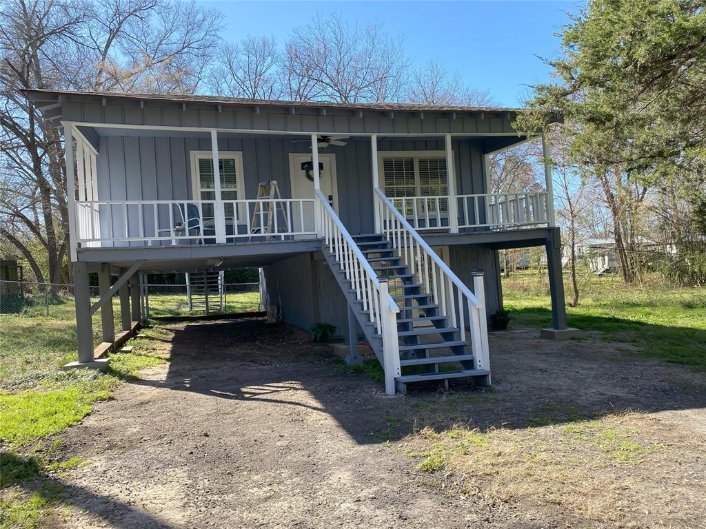 a view of a house with wooden deck front of house