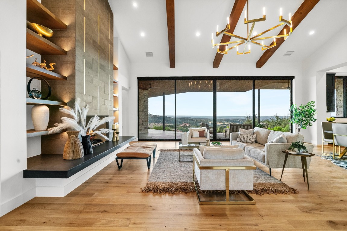 a living room with fireplace furniture and a large window