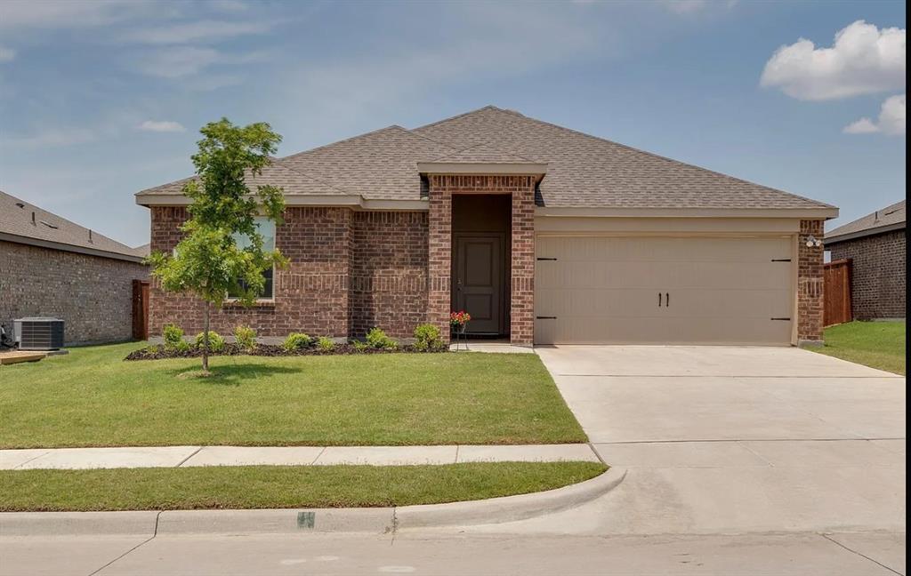 a front view of a house with a garden and yard