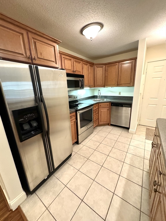 a kitchen with stainless steel appliances granite countertop a refrigerator a sink a stove a microwave and cabinetry