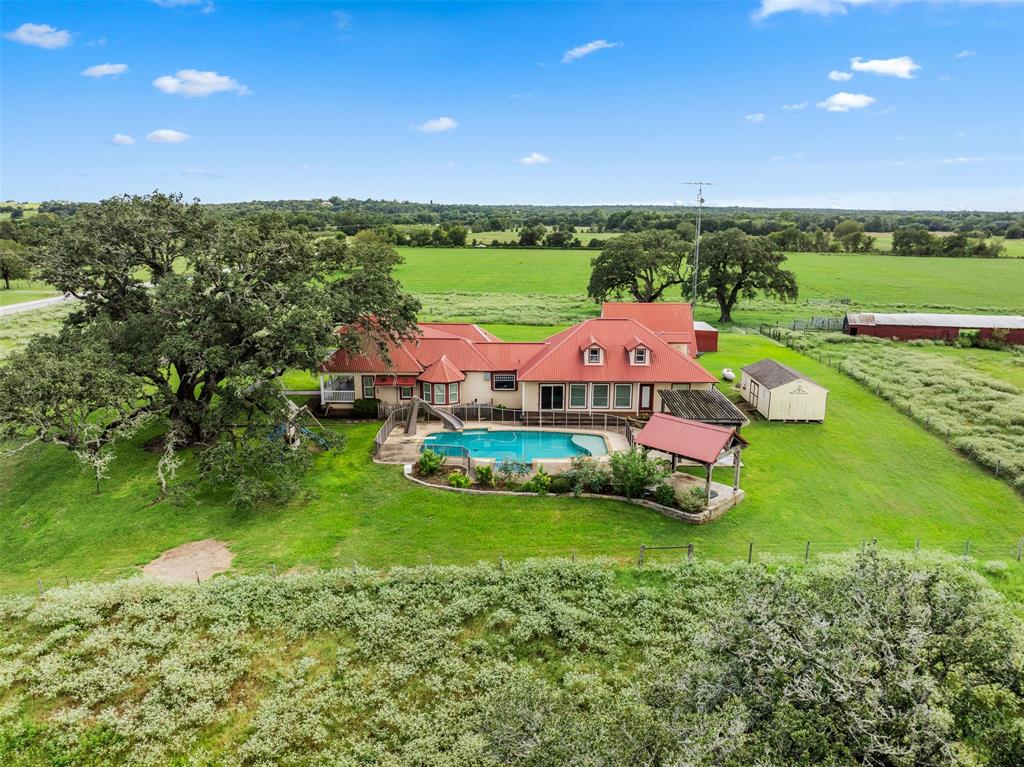 an aerial view of a house with a garden and outdoor swimming pool