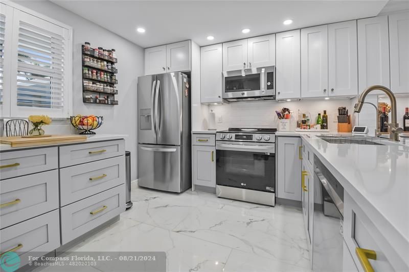 a kitchen with granite countertop a stainless steel appliances cabinets and a sink