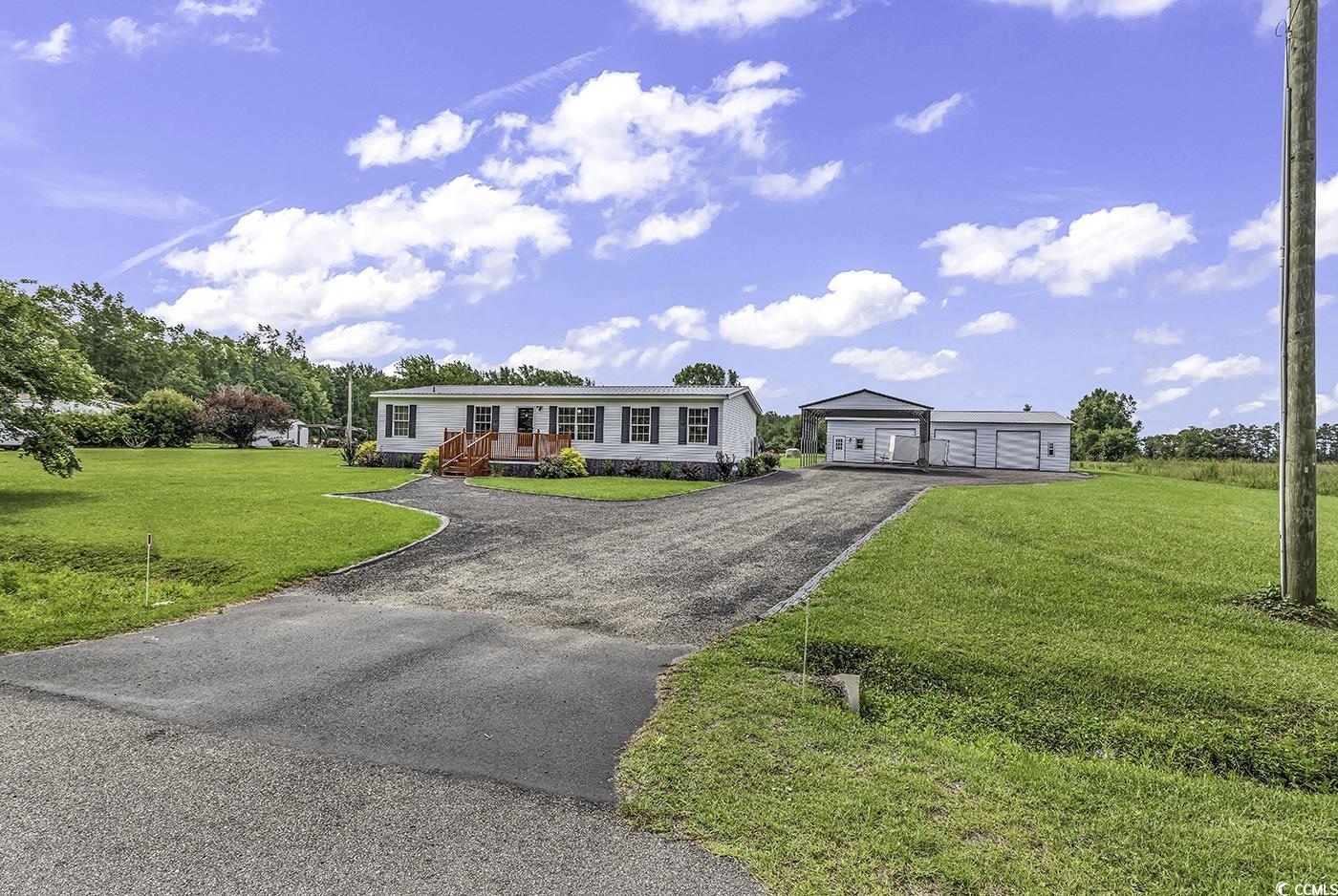 Ranch-style house featuring a garage and a front y