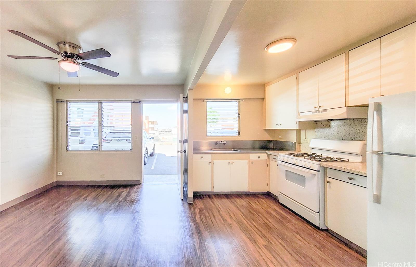 a kitchen with wooden floors and white appliances