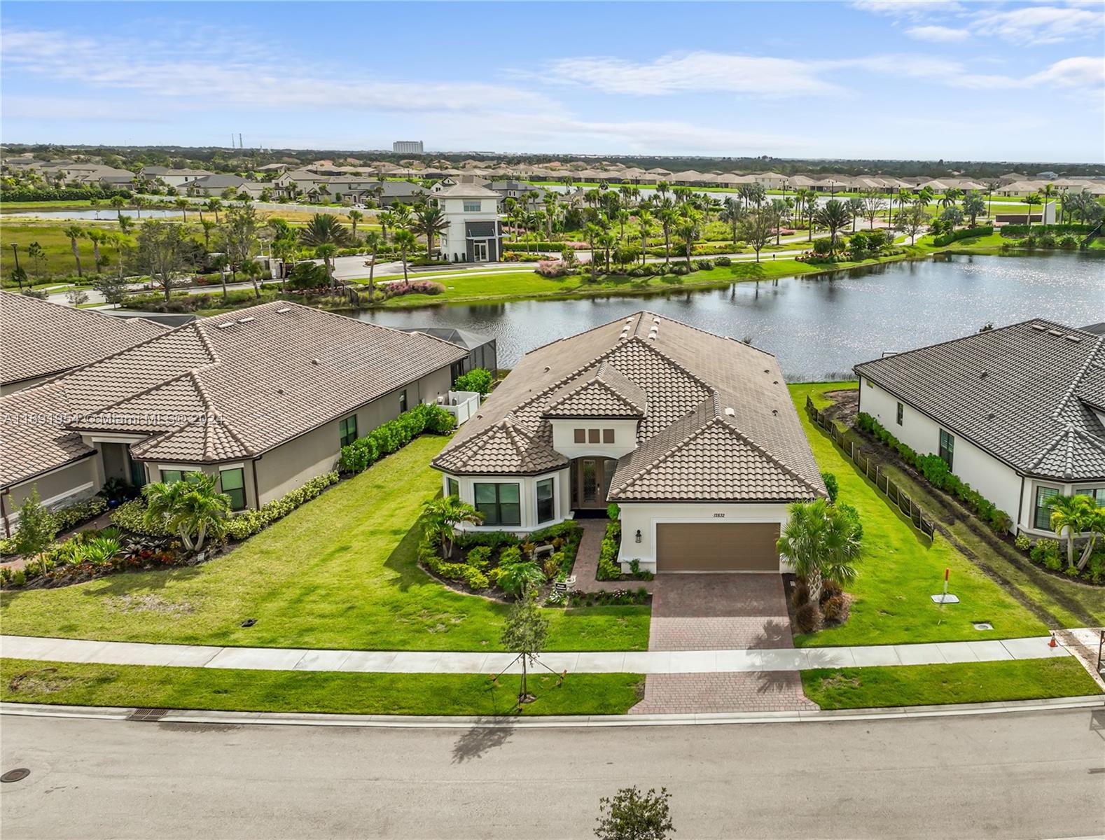 an aerial view of a house with a yard and lake view