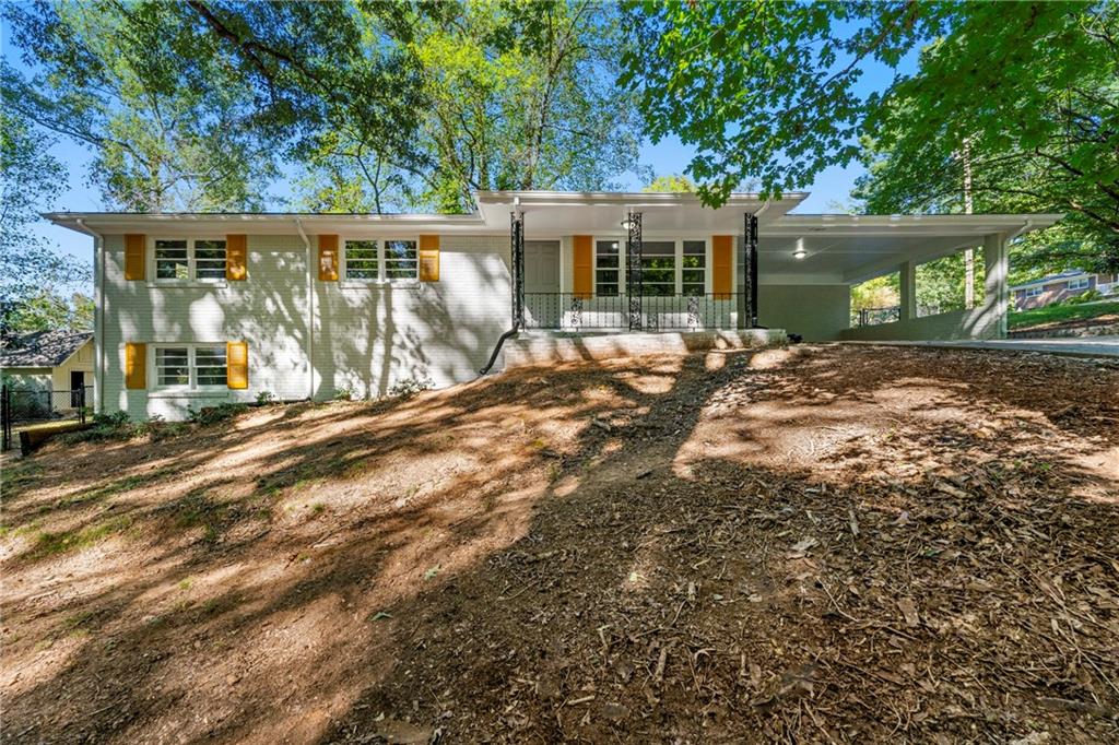 a view of house with backyard and a garden