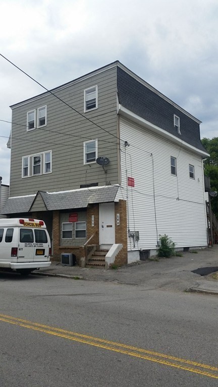 a front view of a house with a parking space