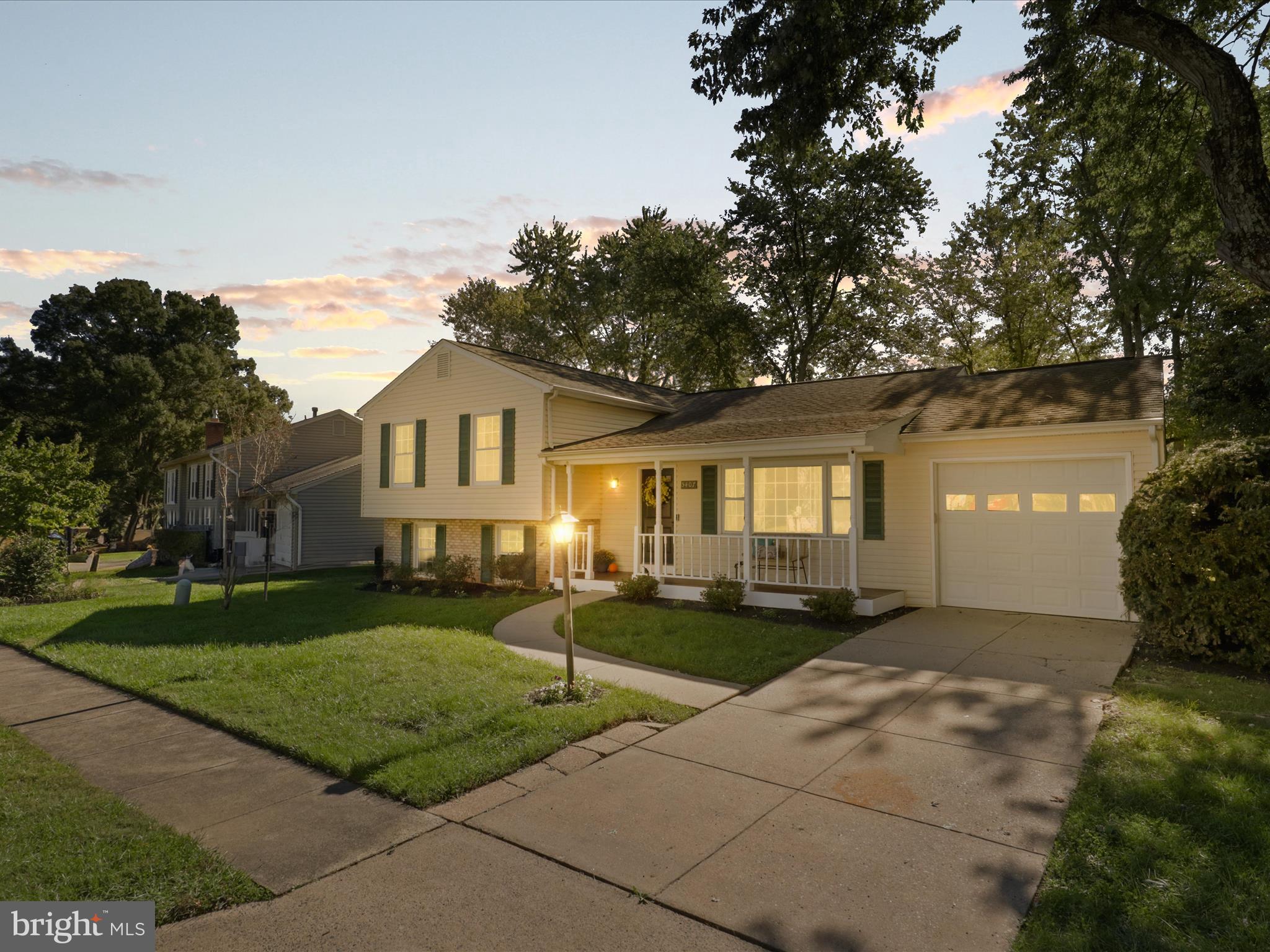 a front view of a house with a yard and trees