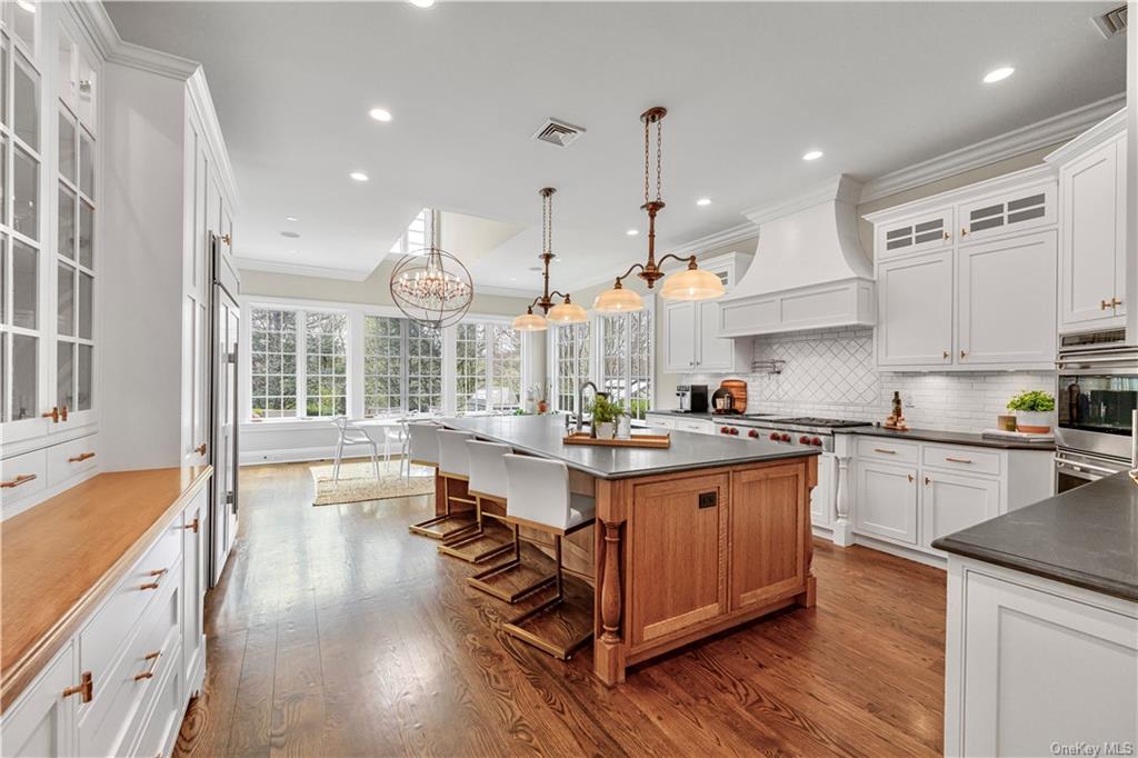 a large kitchen with lots of counter space a sink appliances and a large window