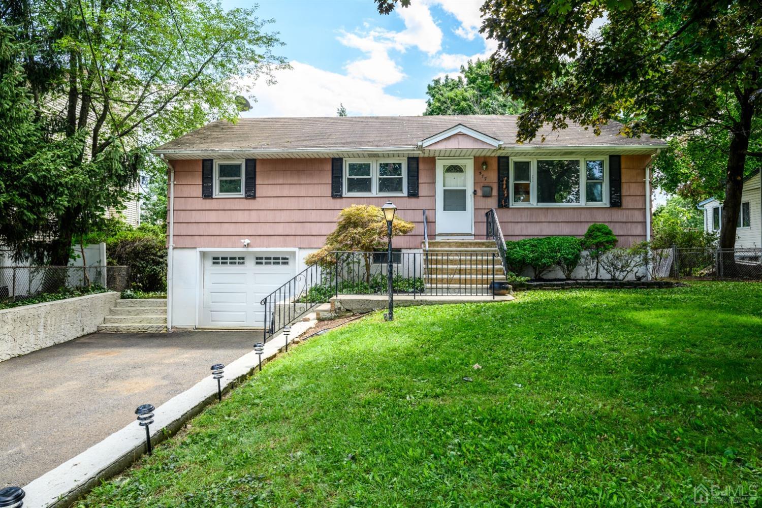 a front view of a house with a yard and green space