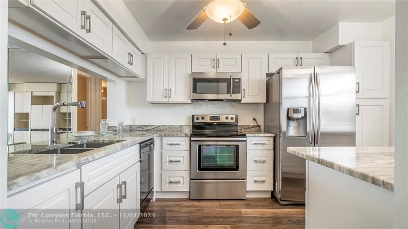 a kitchen with stainless steel appliances granite countertop a stove a sink and a refrigerator