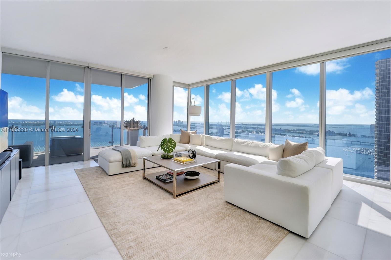 a living room with furniture and floor to ceiling window