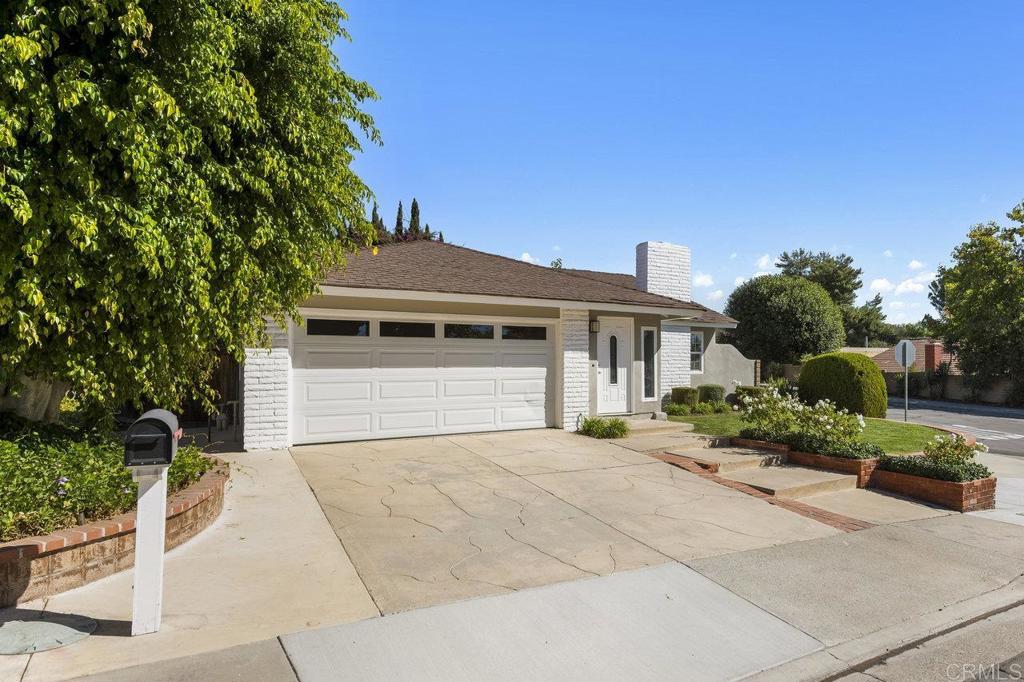 a front view of a house with a yard and potted plants