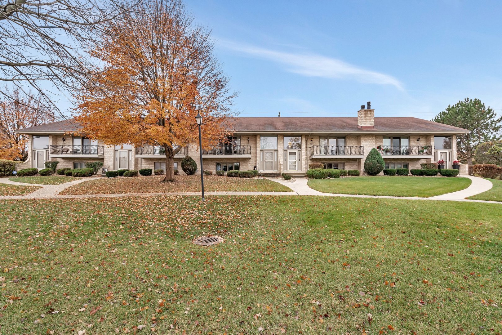 a view of a big house with a big yard and large trees