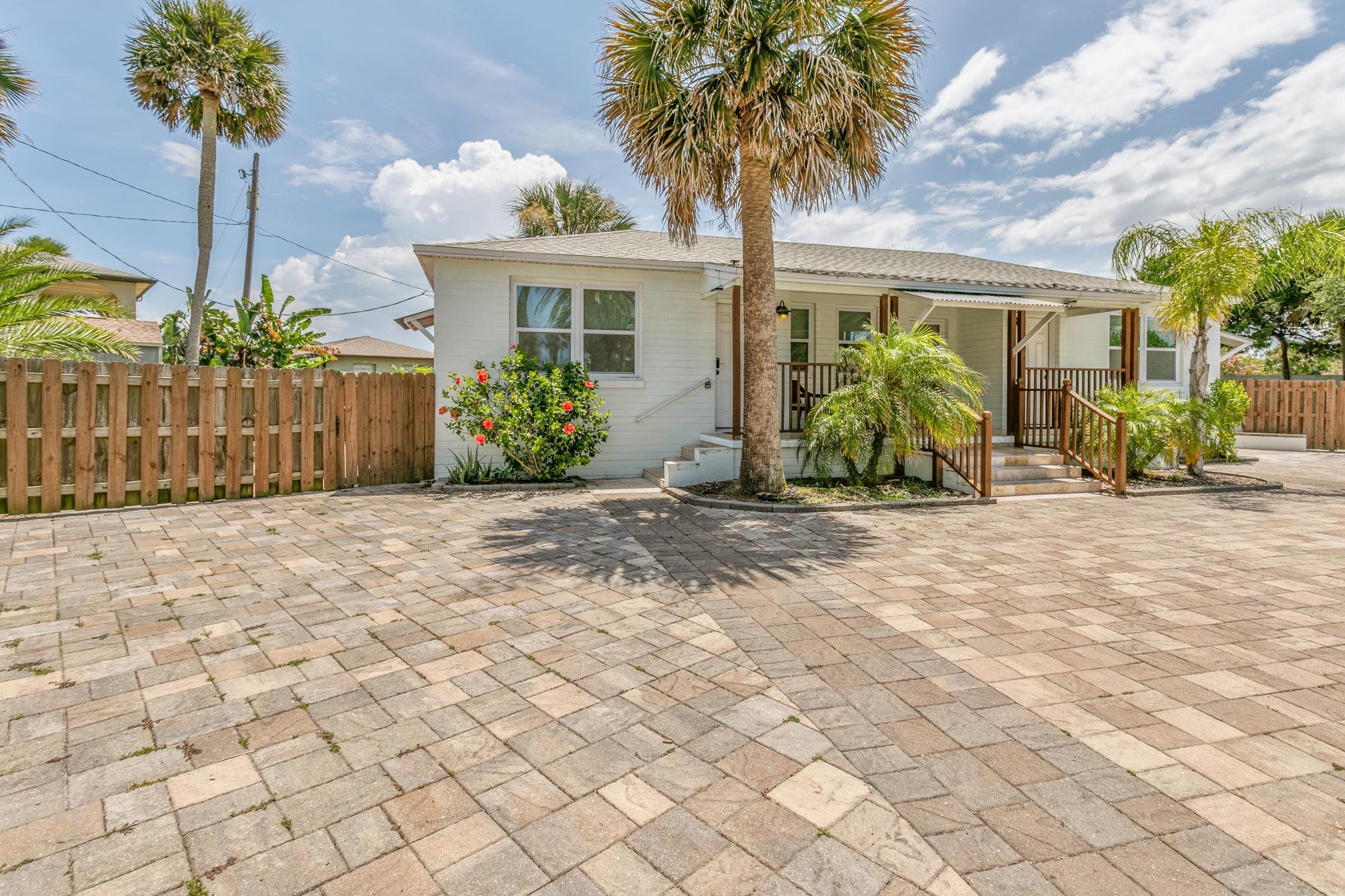 a front view of a house with a yard and potted plants