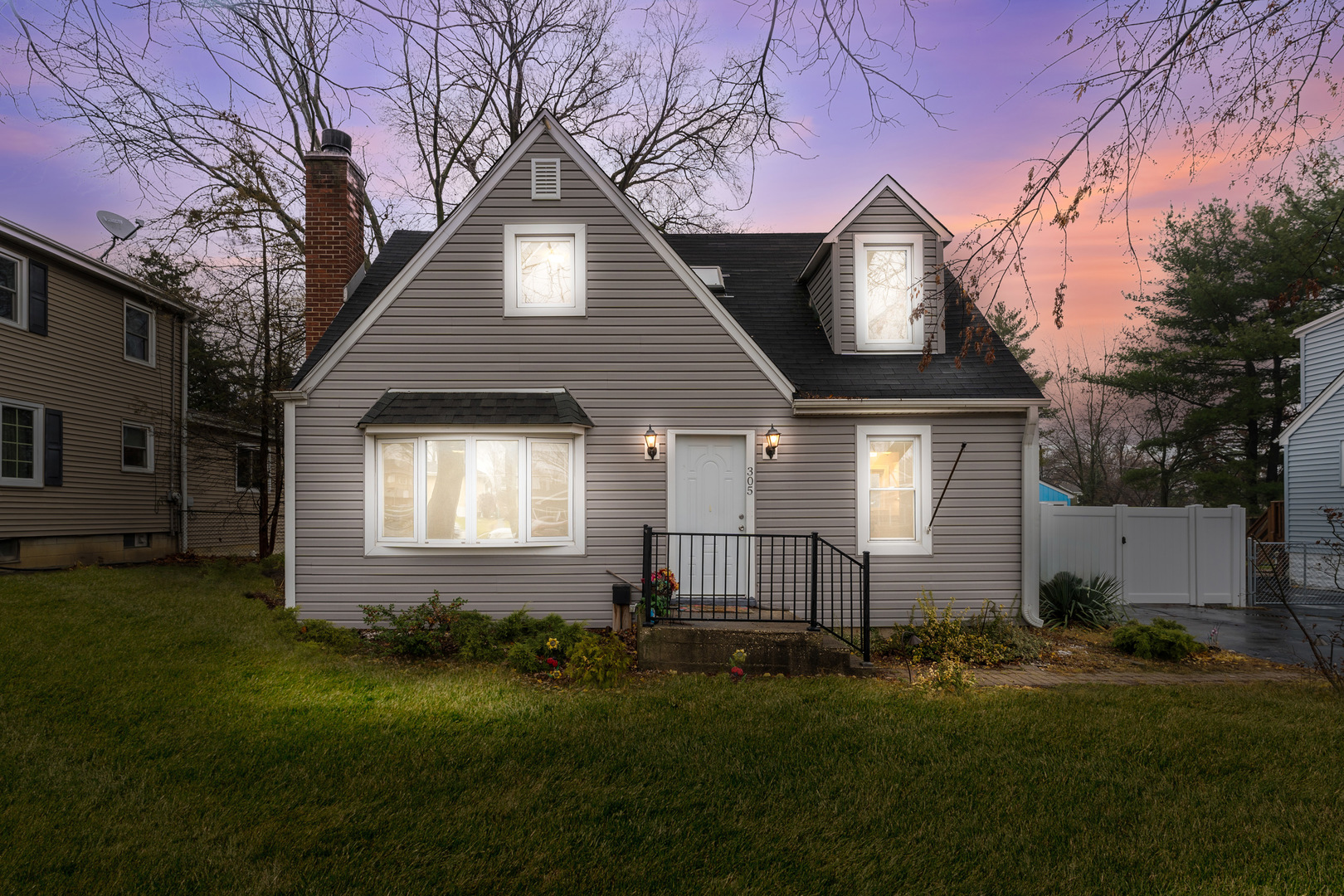 a front view of a house with a garden and yard