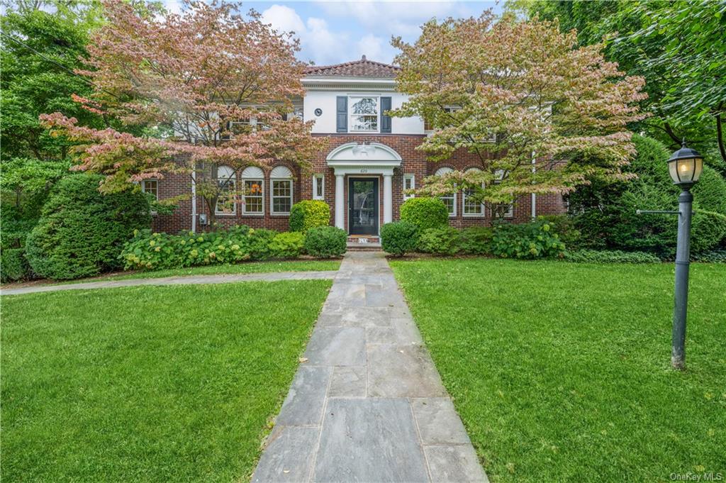 a front view of a house with yard and green space