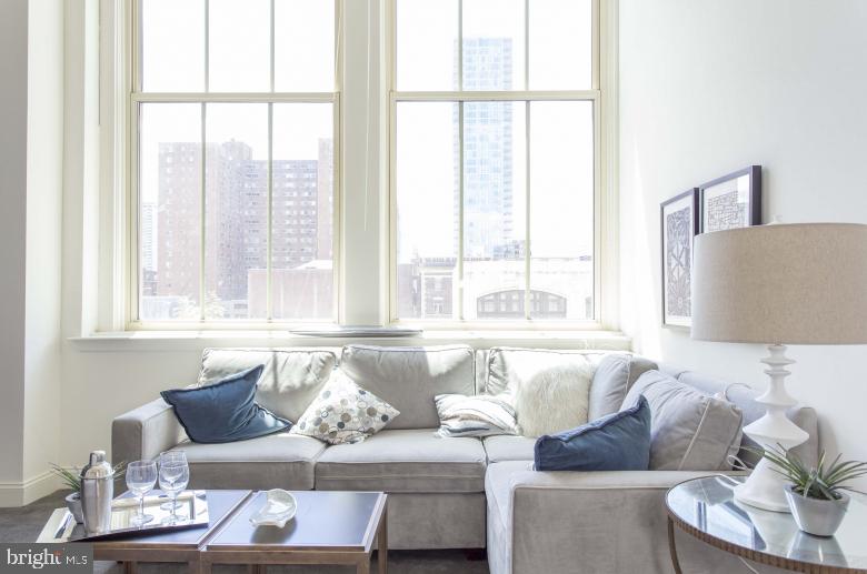 a living room with furniture and floor to ceiling windows