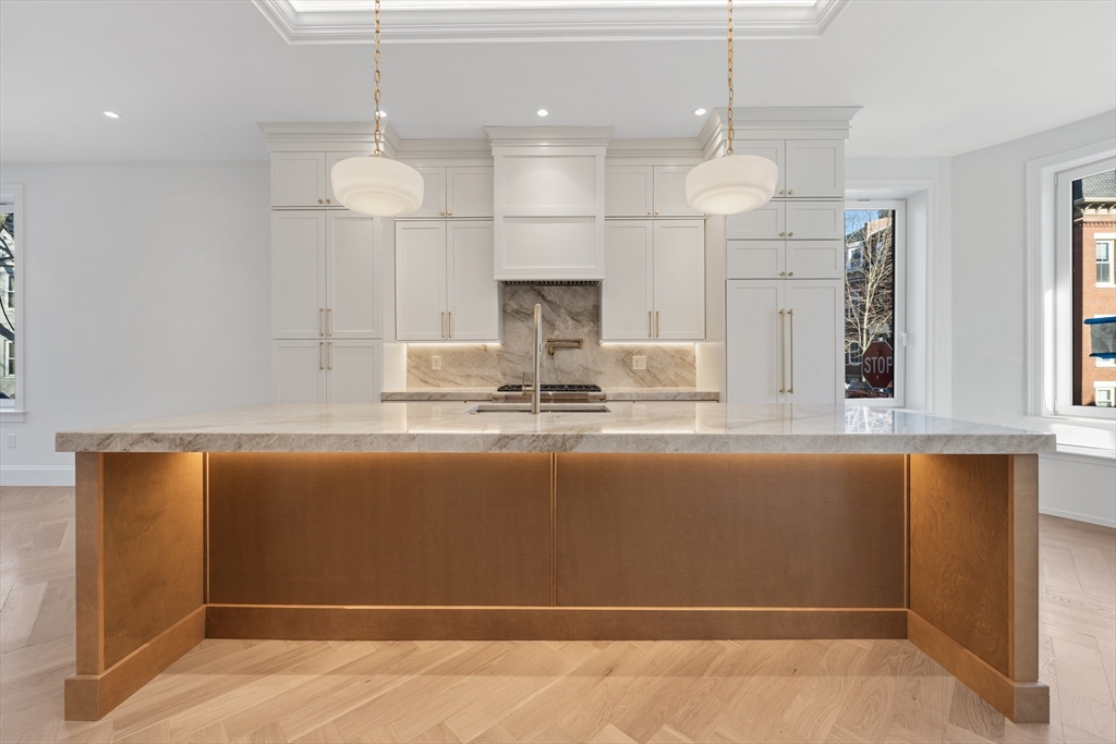 a view of kitchen with granite countertop stove top oven and cabinets