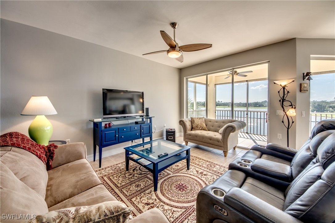 a living room with furniture a flat screen tv and a large window