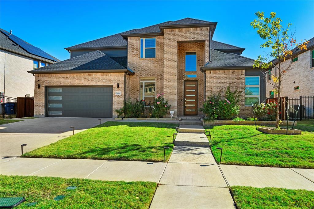 View of front of property featuring a front yard and a garage