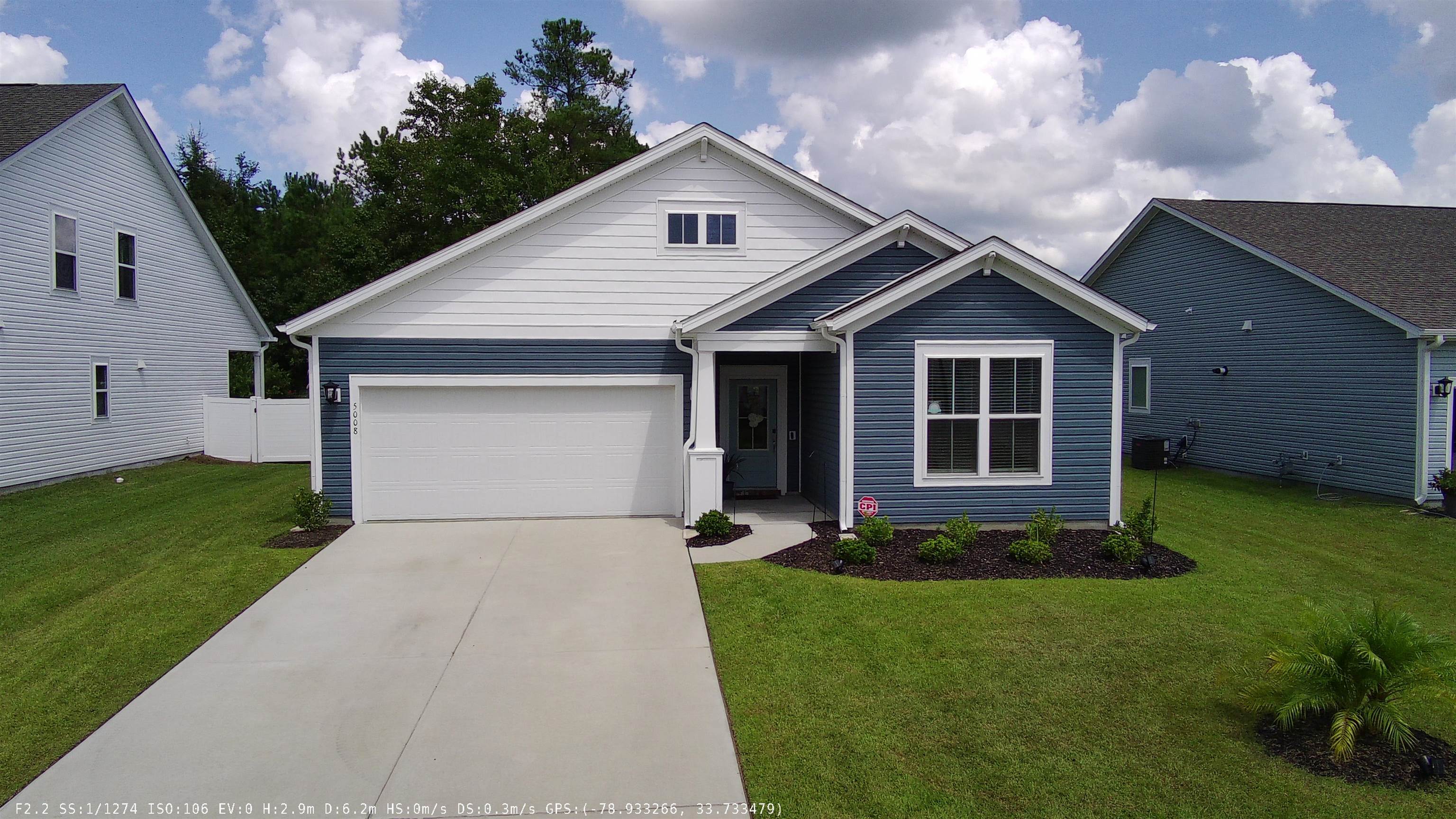 View of front of home with a garage and a front ya