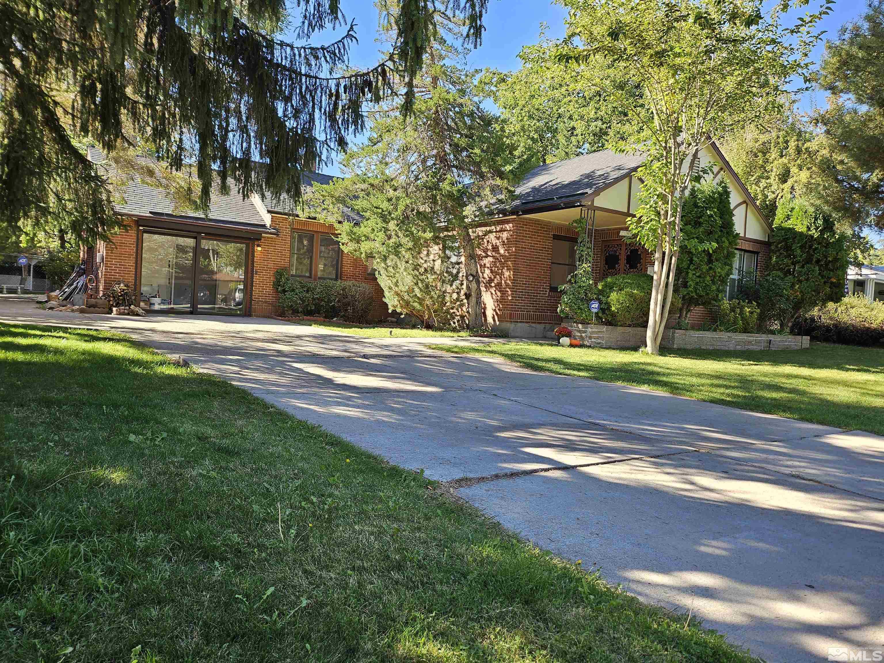 a view of a house with a yard and large trees