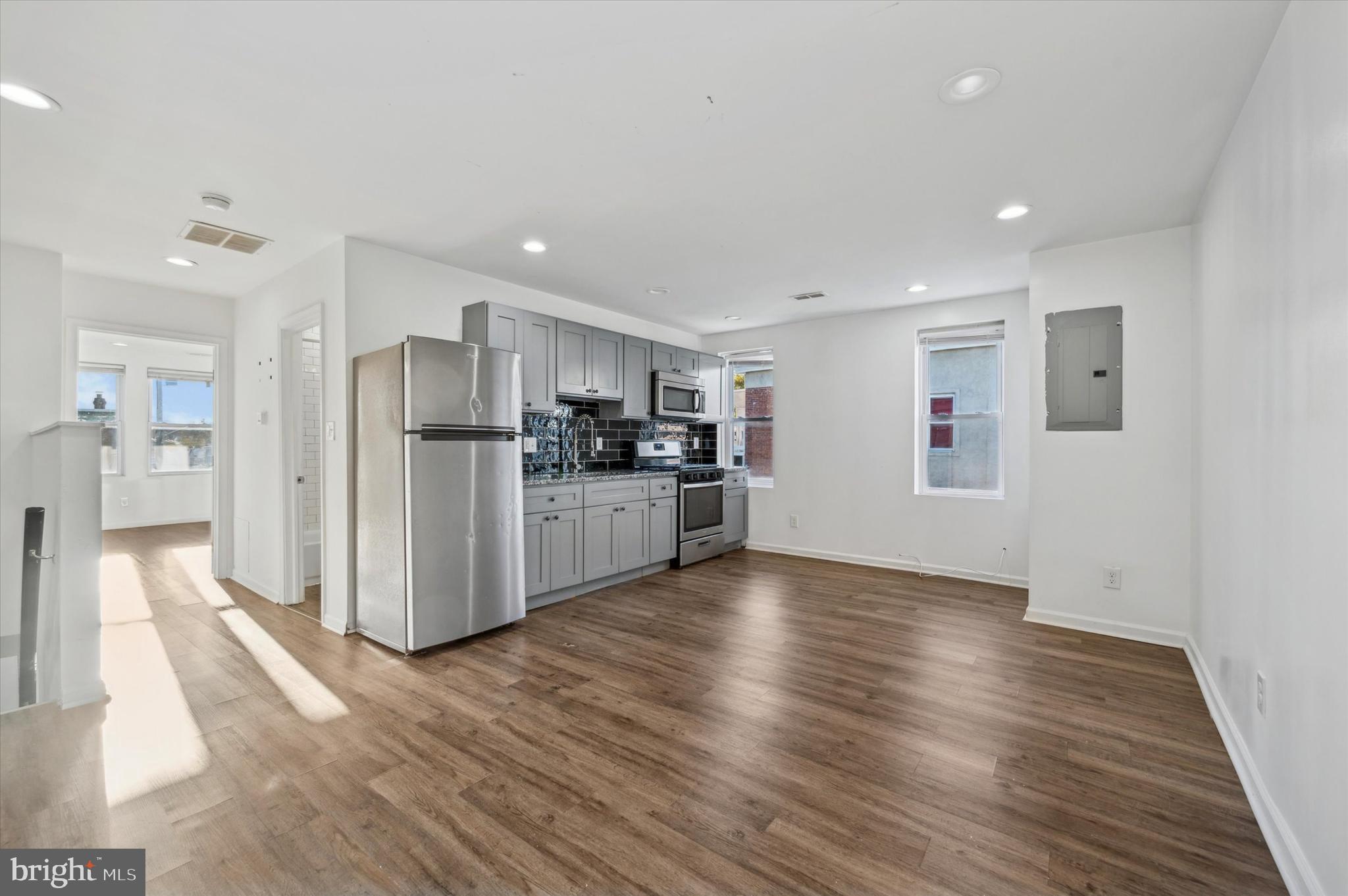 a view of a kitchen with refrigerator and wooden floor