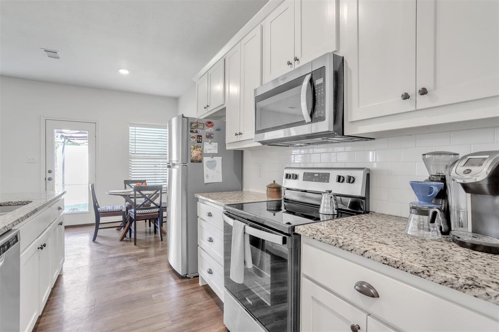 a kitchen with stainless steel appliances granite countertop a stove a sink and a microwave