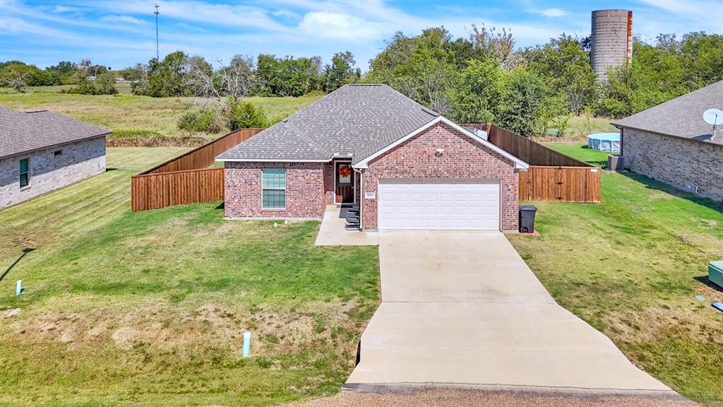 a view of a house with a yard and fence