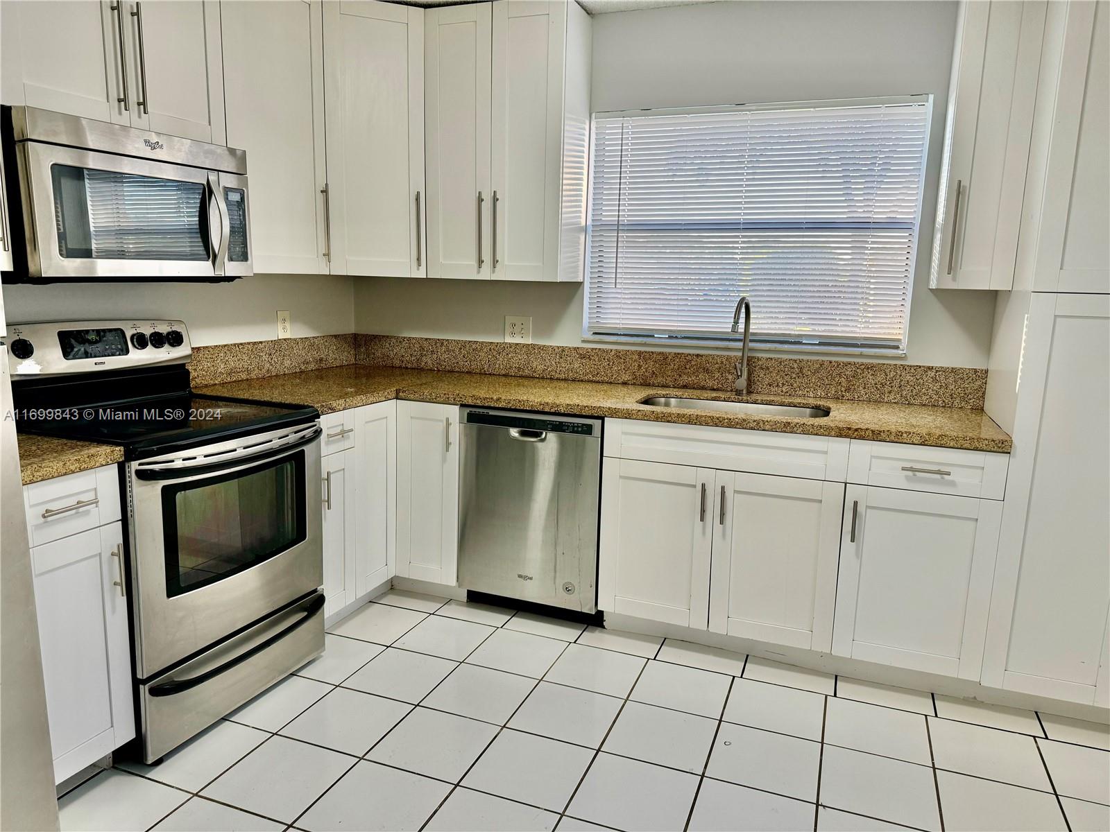 a kitchen with cabinets appliances and a sink