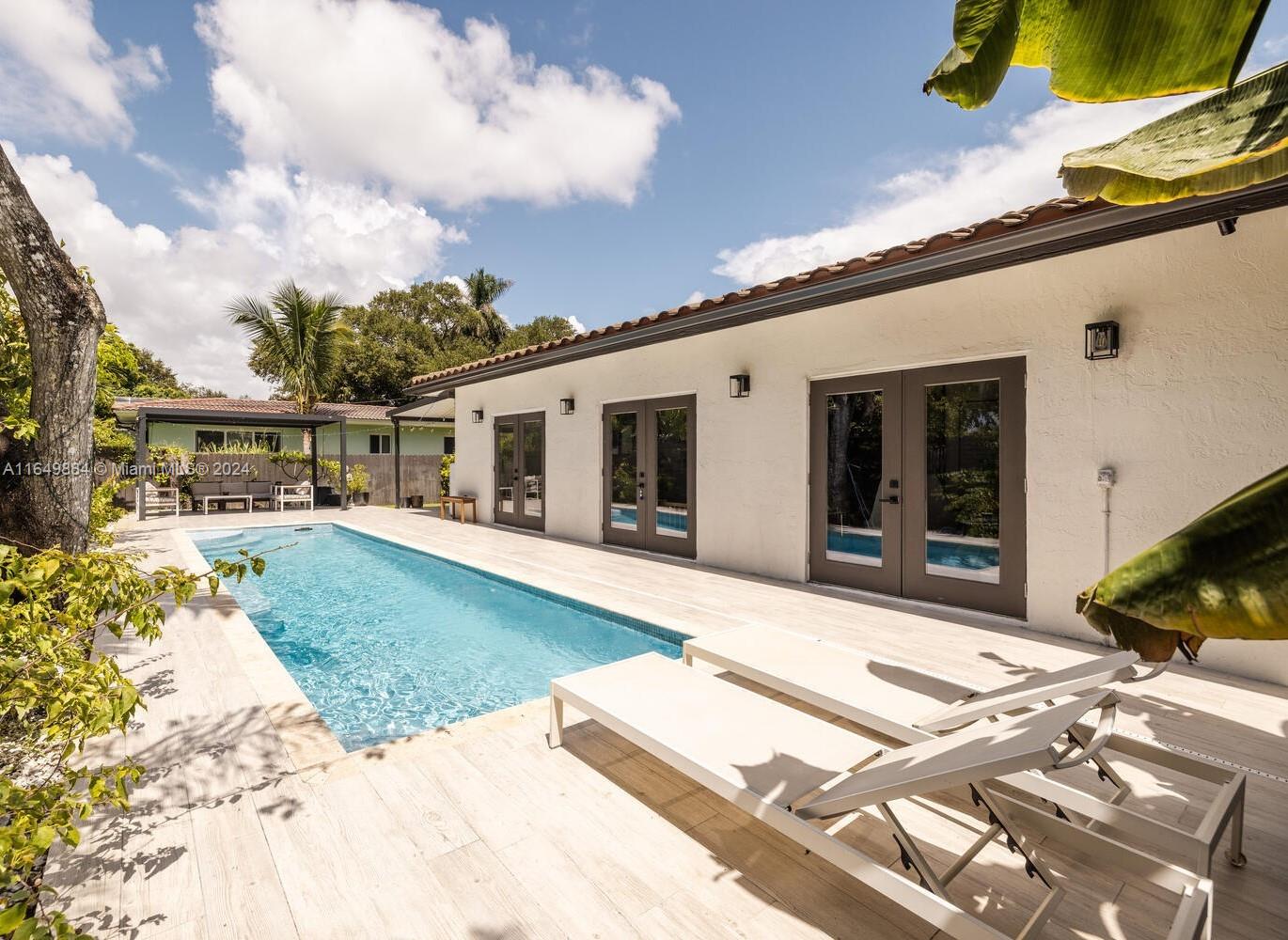 a view of a house with backyard and sitting area