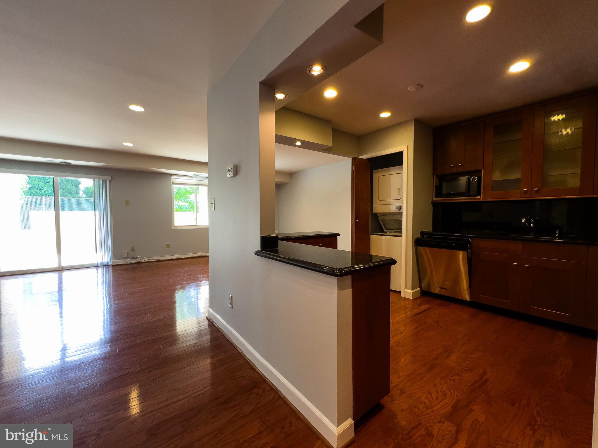 a open kitchen with kitchen island a sink appliances and a counter top space