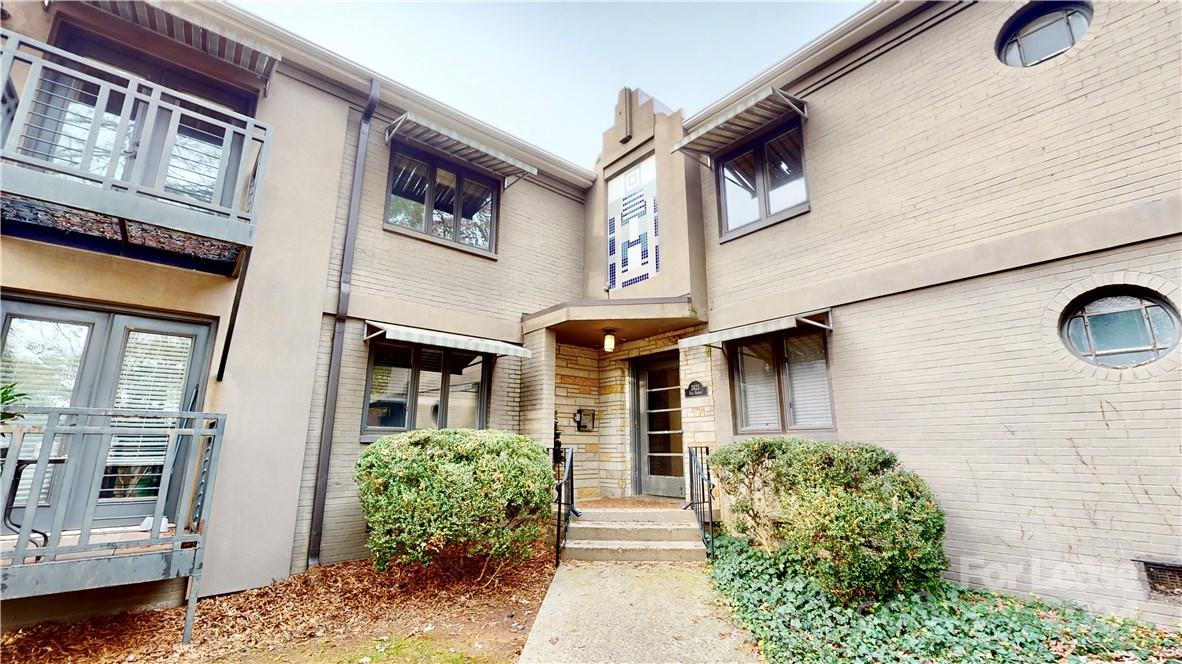 a front view of a building with a garden