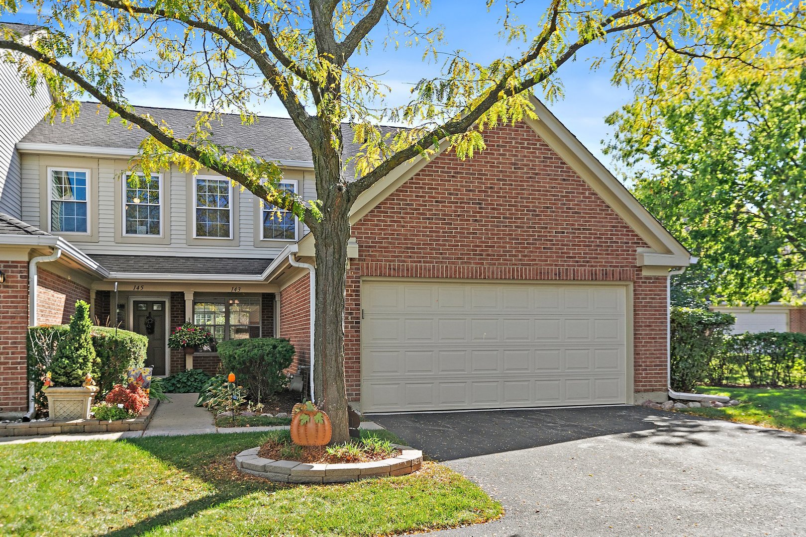 a front view of a house with a yard garage and outdoor seating