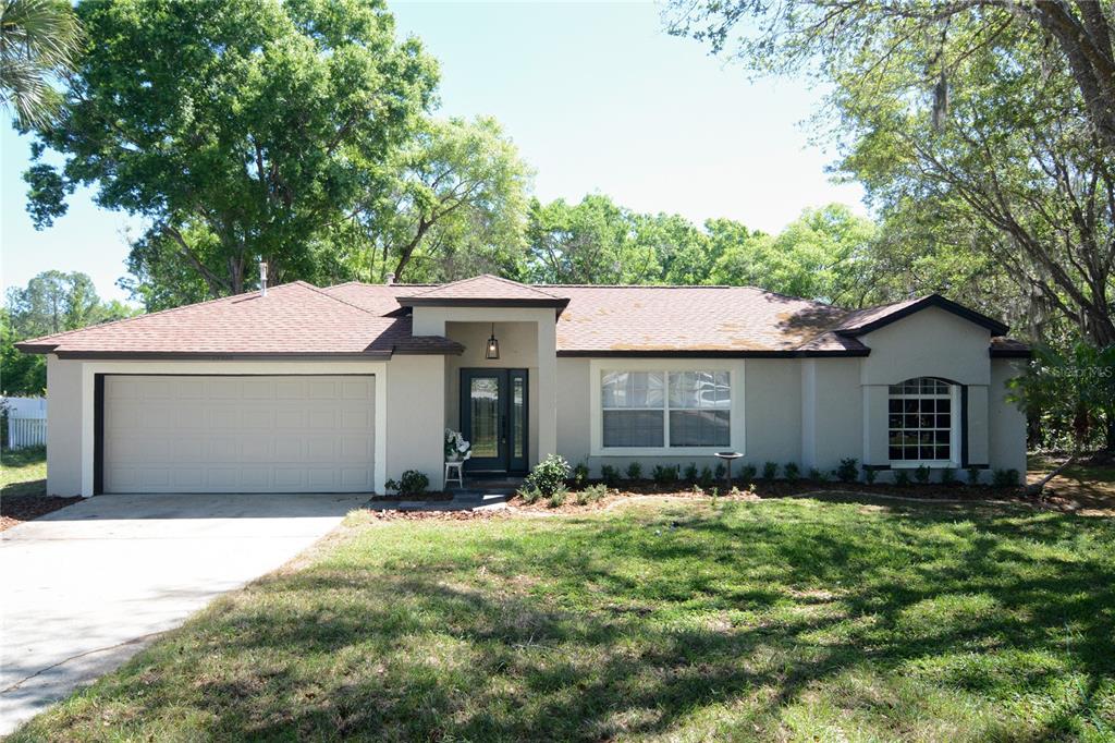 a front view of house with yard and trees around