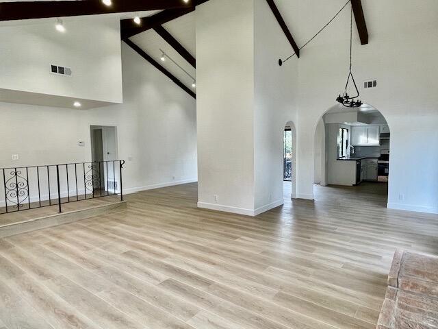 a view of empty room with wooden floor and windows